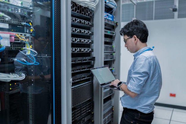 computer engineer is setting up network in server roomsystems maintenance technicianmale engineer working in server room at modern data center