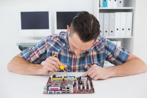 Computer engineer working on cpu with screwdriver