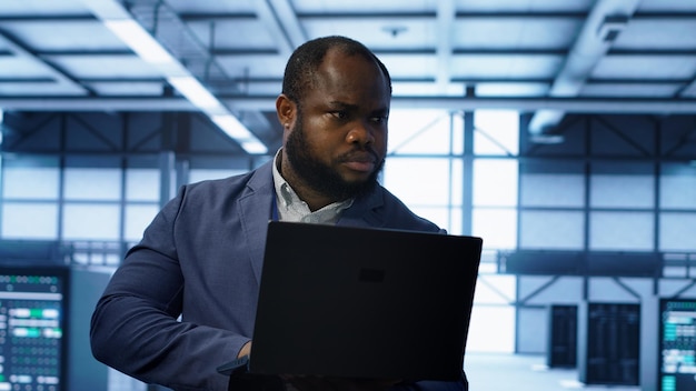 computer scientist in data center using diagnostic tools on laptop