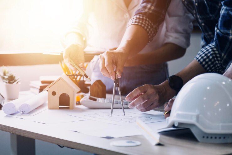 Foto construction engineer working at blueprint to build large commercial buildings in office engineering tools and construction concept