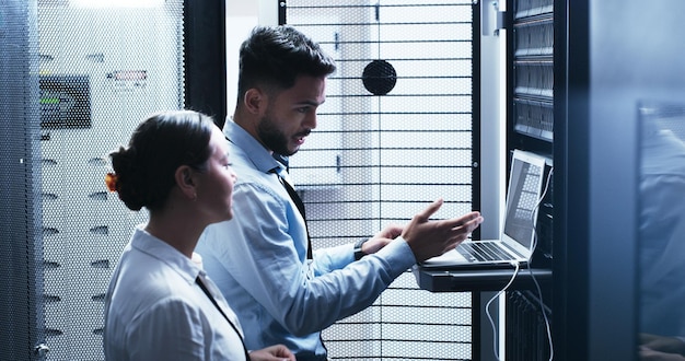 Conversation laptop and problem solving with people in server room for network administration Collaboration computer and cybersecurity with IT support team in data center for troubleshooting