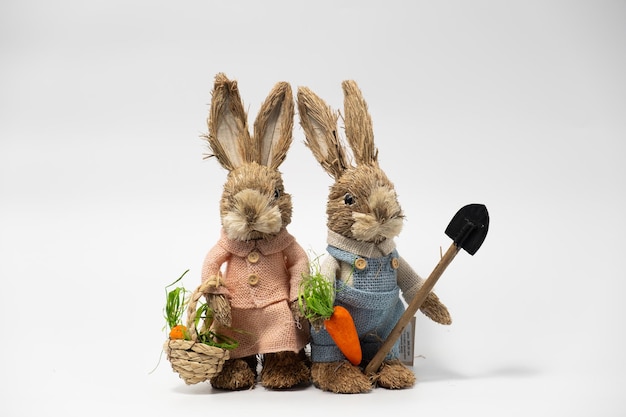 Couple Easter Decorations Hare Rabbits of straw Easter toy rabbit made of straw with a basket isolated on a white background