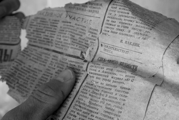 Foto cropped hand holding torn newspaper