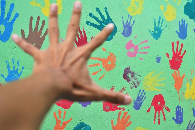 cropped hand of man reaching painted wall