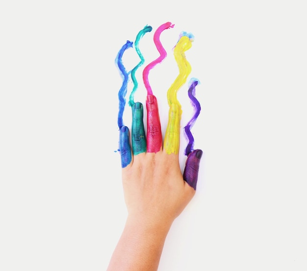 Cropped hand with colorful watercolor paints on white background