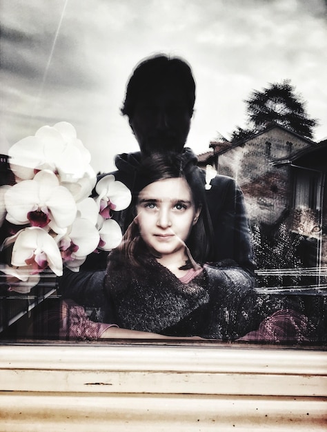Cute girl at home seen through glass window