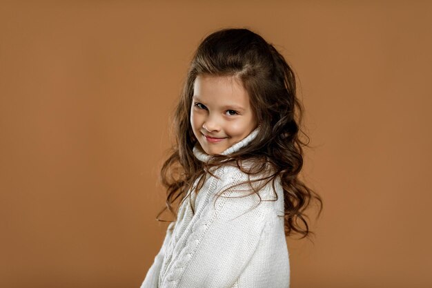 Cute shy little child girl in white sweater