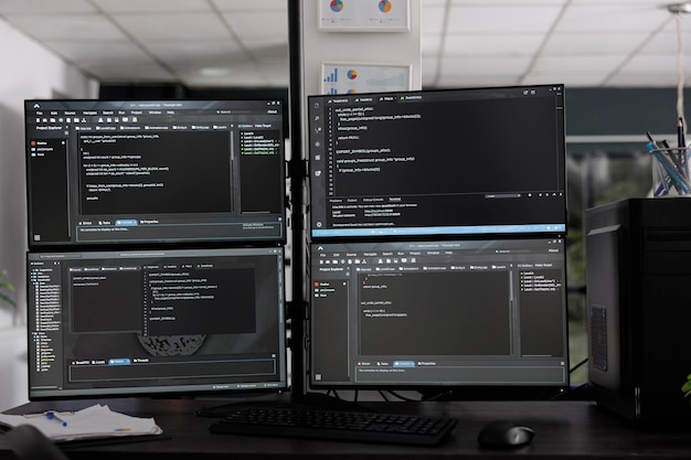Dataskjermer på skrivebordet kompilerer programmering av html-dataalgoritmer i tomt programvareselskap. Databasenettverksservere nettskybasert databehandling i IT-byråets rom, kodeskriptspråk.