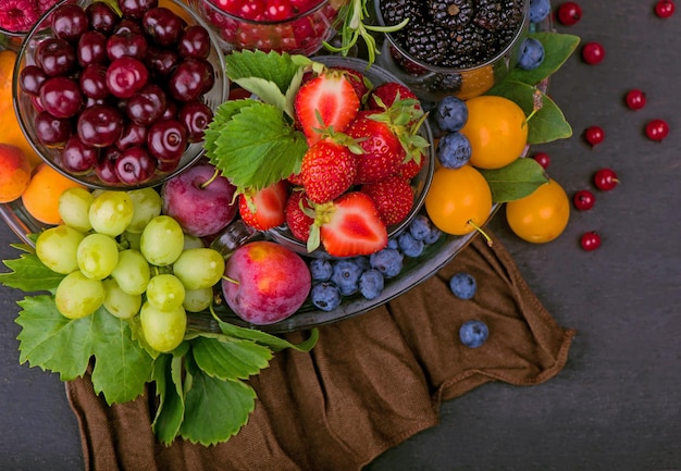 different summer berries red currant, gooseberry, raspberry in glass trays. sorted by type.