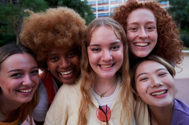 Diverse group of women with heads together smiling united for equality and womens right