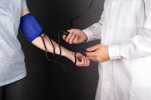 Doctor checks the pressure of the patient.