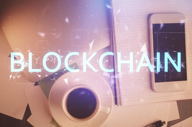 double exposure of blockchain theme hologram over table with phone top view crypto technology concept