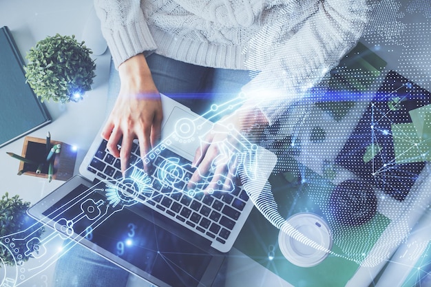 Double exposure of woman hands working on computer and tech theme hologram drawing Top View Technology concept