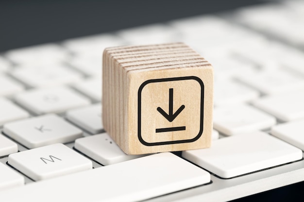 Download icon on wooden block on computer keyboard Downloading data storage