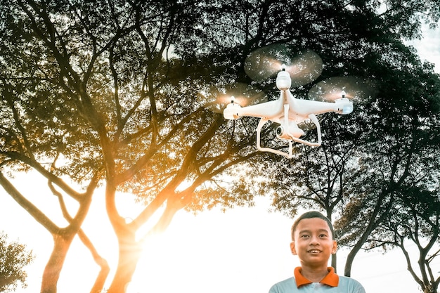 Drone flying over boy against tree