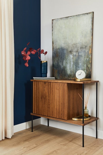 Elegant details of modern gramour interior design with wooden sideboard, painting and stylish personal accessories. Template.