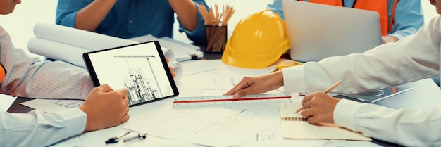 Engineer and architect working together brainstorming and designing blueprint using laptop working with architectural software for precise digital interior or structure design Insight