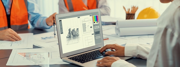engineer and architect working together brainstorming and designing blueprint using laptop working with architectural software for precise digital interior or structure design insight