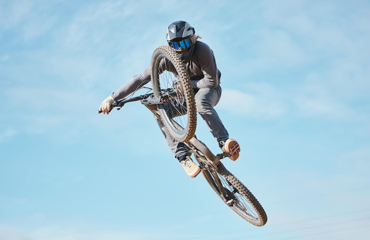 Foto extreme sports bike jump and cyclist cycling a bicycle for competition stunt routine or training speed in mockup space skill contest and athlete workout or practice sky or air trick for fitness