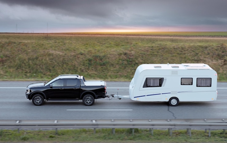 Foto family vacation trip on black pickup truck with white camper trailer