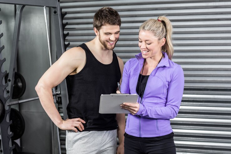 Foto female trainer talking with client at crossfit gym