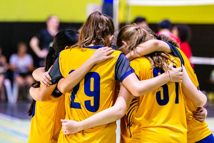 Foto female volleyball players huddling together before starting the game