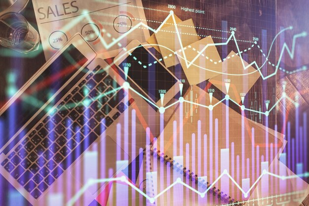 financial market graph and top view computer on the desktop background multi exposure investment concept