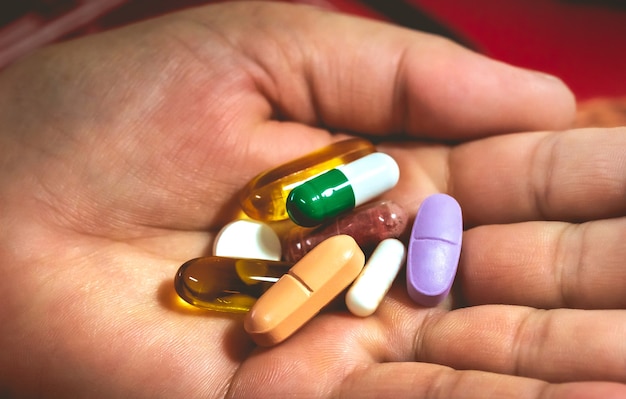 Food supplement capsules and vitamins in a womans hand in macro photo