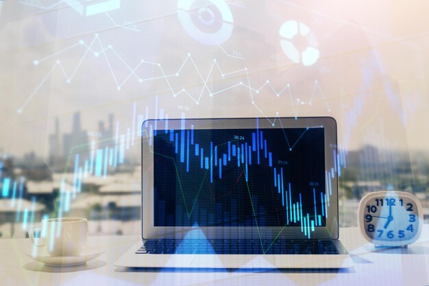 Forex graph hologram on table with computer background Multi exposure Concept of financial markets