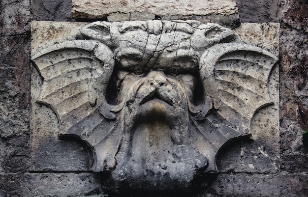 Gargoyle on the wall in the garden.