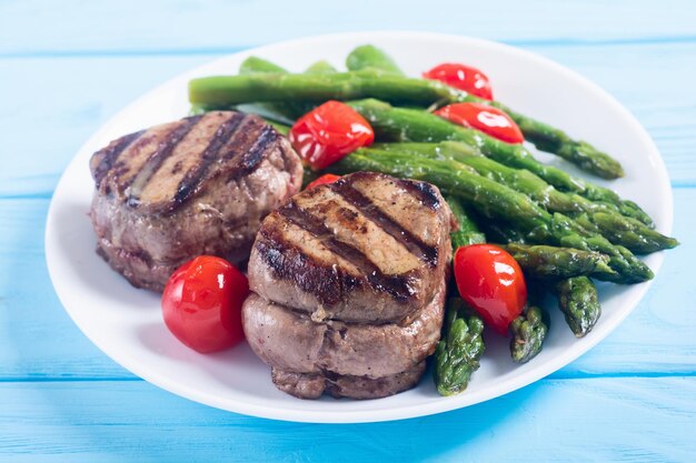 grilled filet mignon with asparagus and tomatoes beef sreak on rustic background