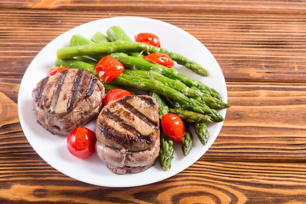 grilled filet mignon with asparagus and tomatoes beef sreak on rustic background