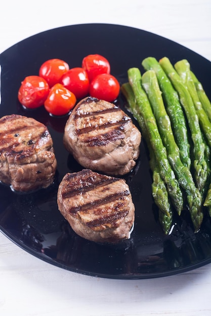 grilled filet mignon with asparagus and tomatoes beef sreak on rustic background