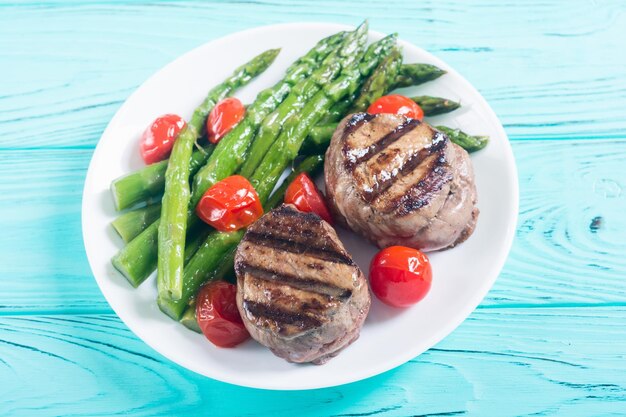 Grilled filet mignon with asparagus and tomatoes Beef sreak on rustic background