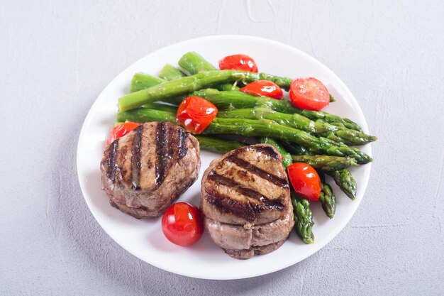 grilled filet mignon with asparagus and tomatoes beef sreak on rustic background
