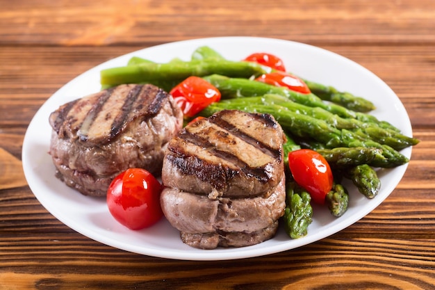 grilled filet mignon with asparagus and tomatoes beef sreak on rustic background