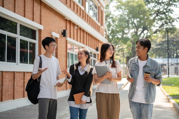Group of diverse cheerful Asian students friends are enjoying talking while walking in their campus