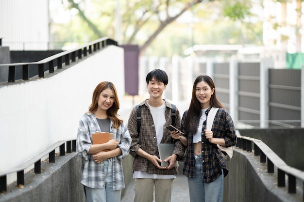 Group of happy students walking with notebook and laptop computer walking into the classroom