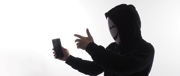 Hacker Anonymous and face mask with smartphone in hand