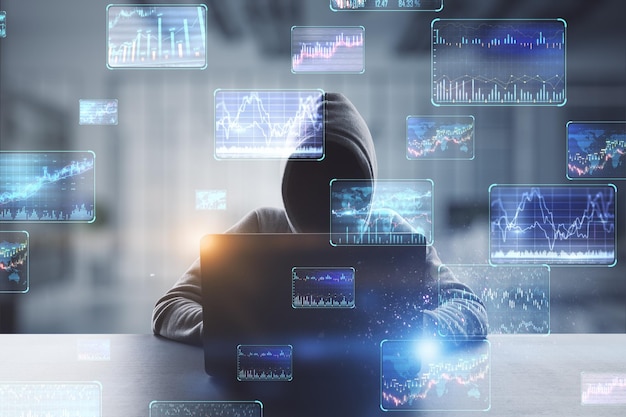 Hacker at desktop using laptop with various forex screens on blurry office interior background Cryptocurrency hacking bticoin trading and finance concept Double exposure