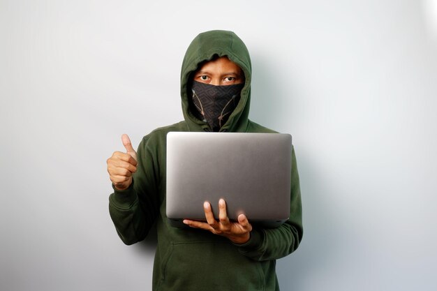 Hacker in front of his laptop trying to steal personal data from people isolated on white background