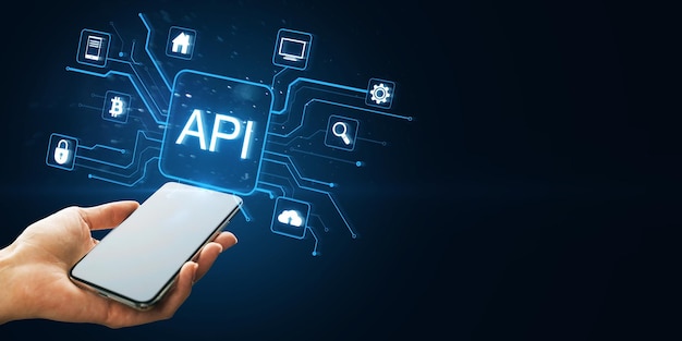 Hand holding smartphone with holographic API icons connected to various technology symbols on dark blue background