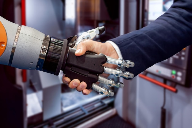 hand of a businessman shaking hands with a android robot. the concept of human interaction with artificial intelligence.
