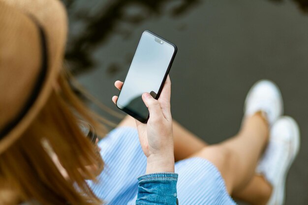 Hand showing smartphone with blank screen isolated on white background