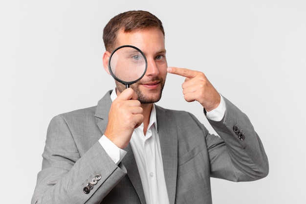 handsome businessman finfing with a magnifying glass