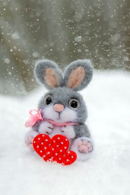 happy valentines day greeting card or banner plush rabbit holding a red heart symbol of love holiday...
