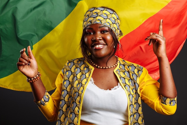 Happy young smiling african woman with the flag of congo republic on background