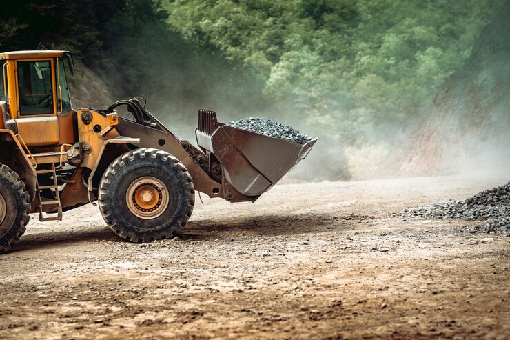 Foto heavy duty industrial wheel loader loading granite rock and ore at crushing and sorting plant