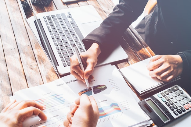 High angle view of business people discussing on pie chart at desk