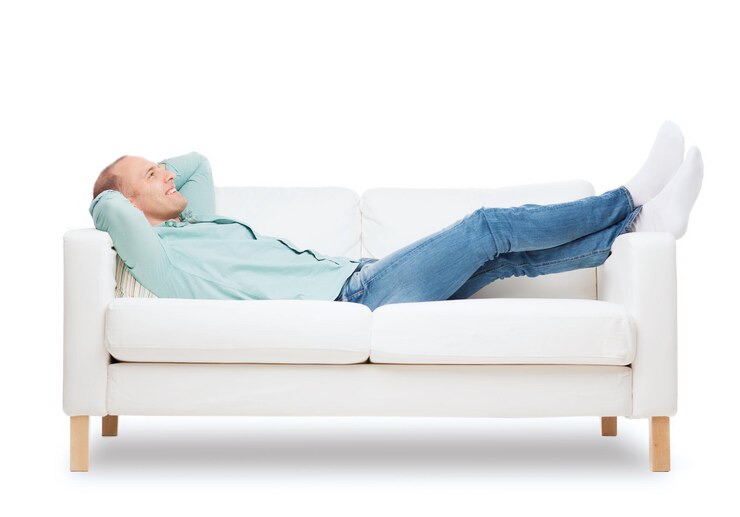 Foto home, leisure and happiness concept - smiling man lying on sofa